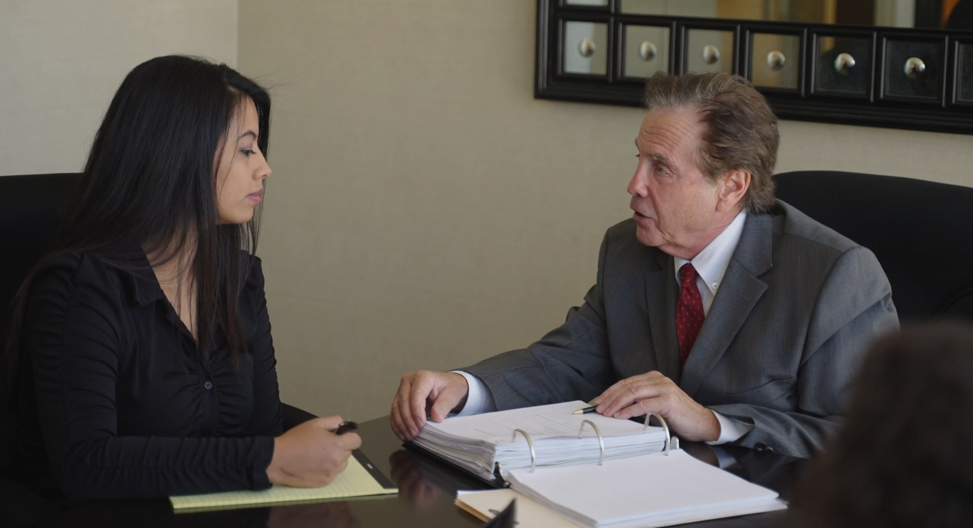Attorney Jeffrey Nadrich discussing a case file with a colleague